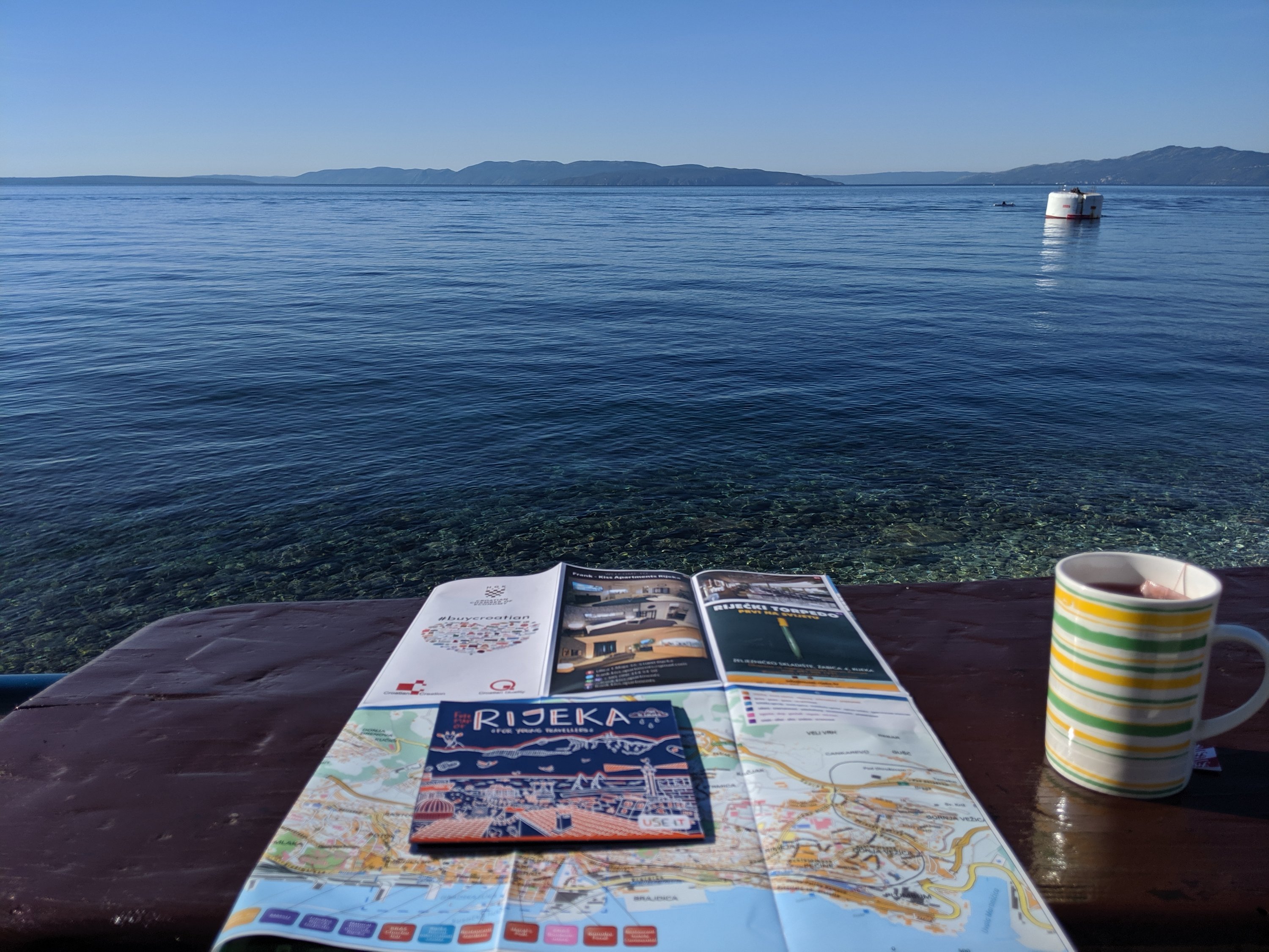 Crystal blue sea with a cup of tea